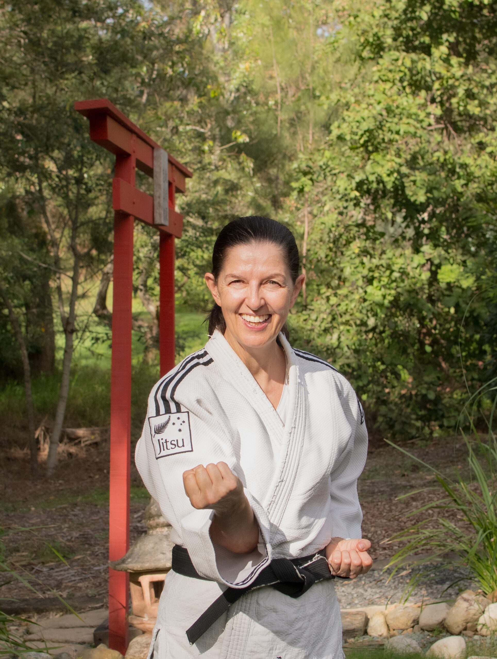 Fiona Spence., master mindset coach, wearing judo gi and black belt in fighting stance